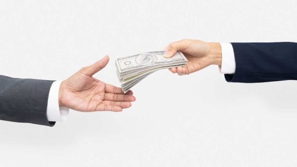 Eine Person gibt einer anderen Geld als Entschädigung für einen Puretech-Motorschaden