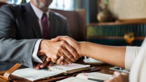 Deux personnes se serrant la main lors d'une négociation à l'amiable du recours collectif contre Puretech.